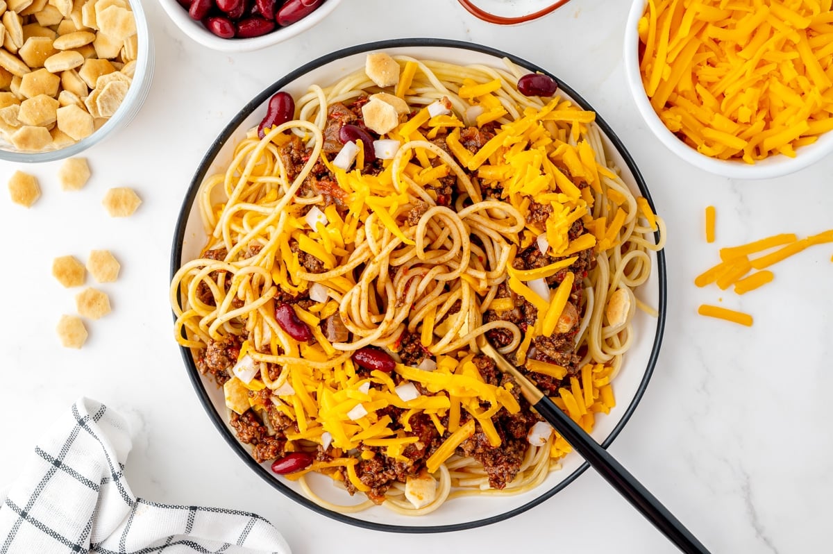 overhead shot of skyline chili over pasta in bowl with fork