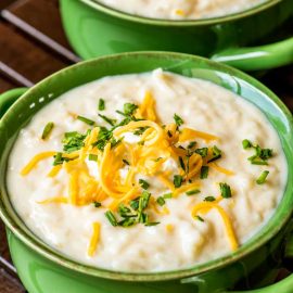 angled shot of green bowl of potato soup