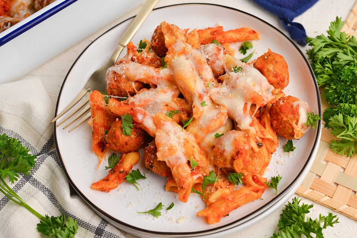 angle of pasta dish with cheese and meatballs on a plate