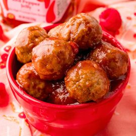angled shot of bowl of raspberry red pepper jelly meatballs