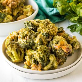 angled shot of cheesy broccoli on a plate