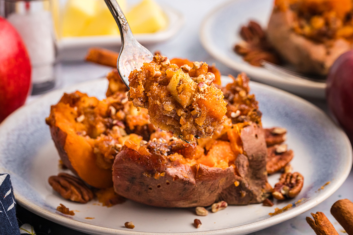 straight on shot of fork taking bite of apple spiced stuffed sweet potato