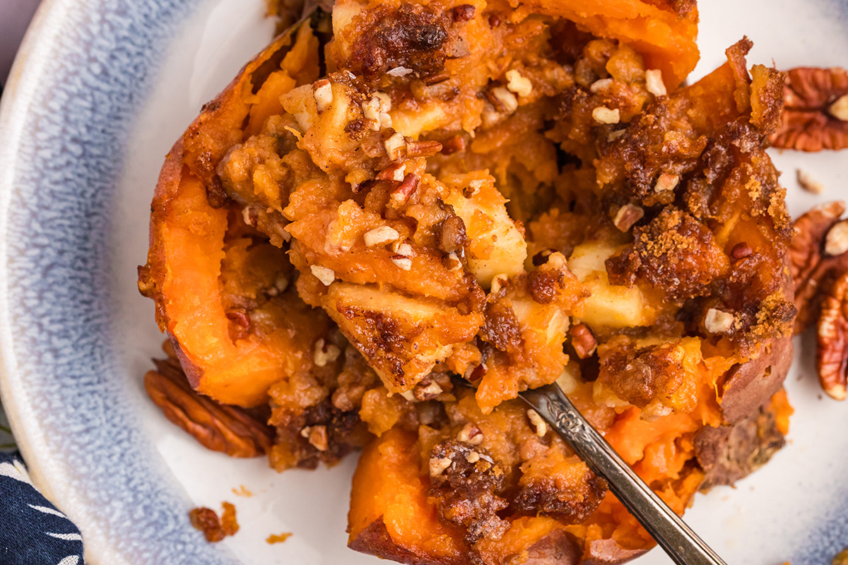 close up overhead shot of fork taking bite of apple spiced stuffed sweet potato