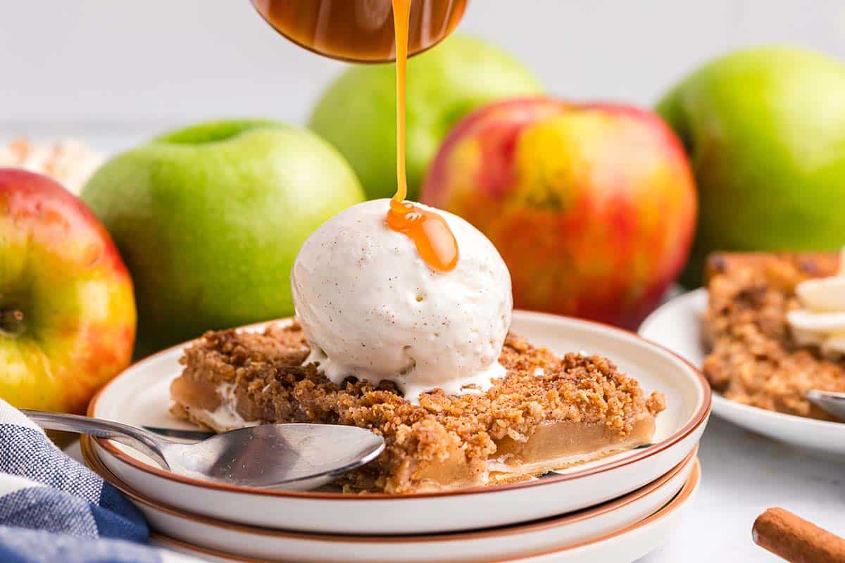 caramel sauce drizzled on top of ice cream on apple pie