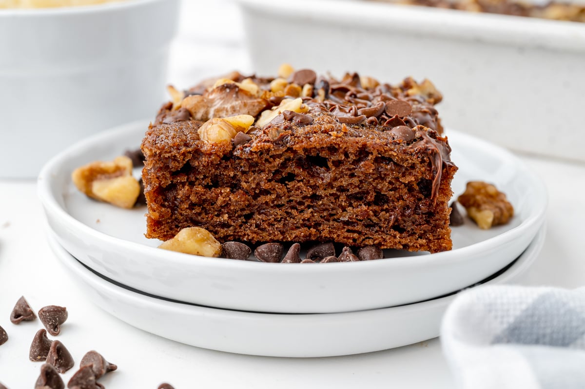 slice of moist brownie baked with applesauce on a stack of white plates