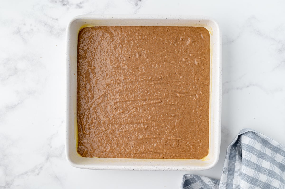 unbaked applesauce brownie batter in a square baking pan