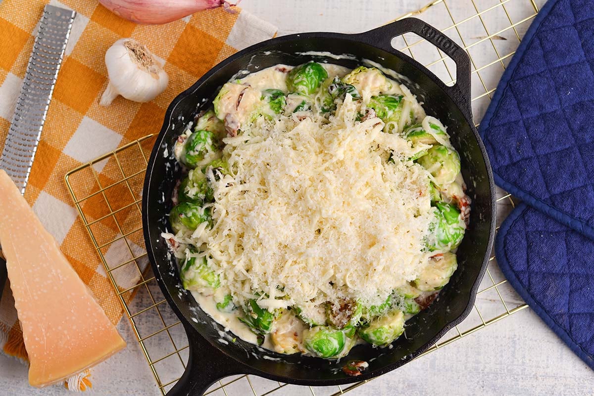 cheese sprinkled onto brussels sprouts in pan