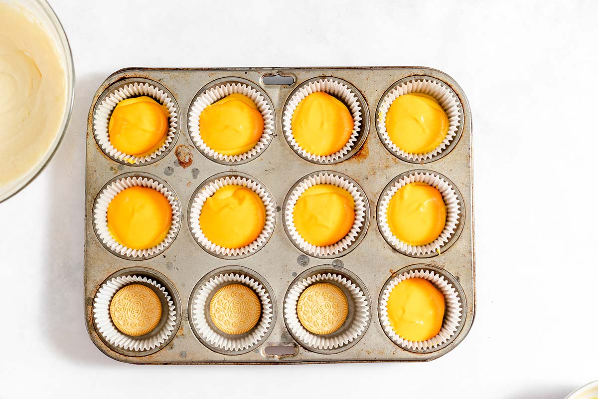 orange cheesecake layer in a muffin tin