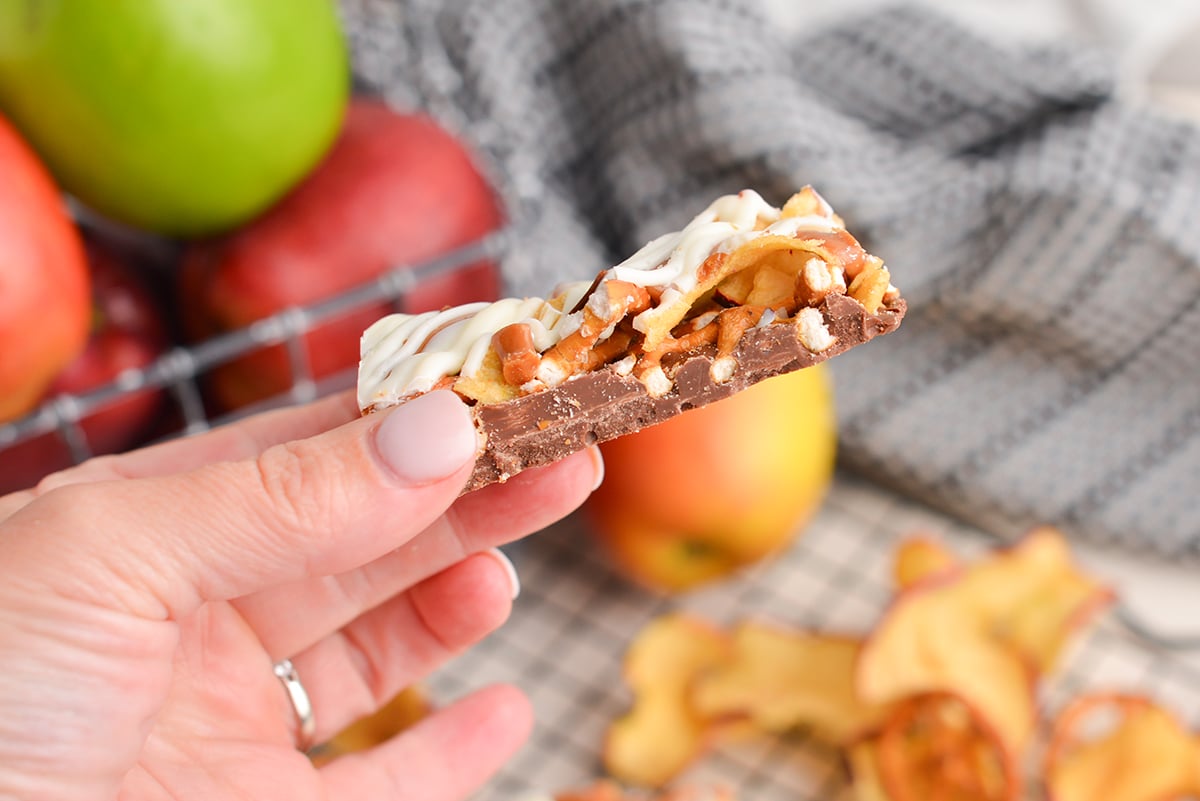 hand holding a piece of caramel apple bark