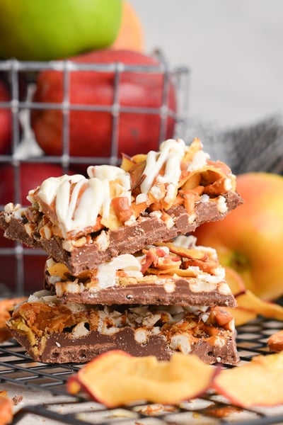 side view of stack of 3 pieces of bark with pretzels, apples, caramel and apples