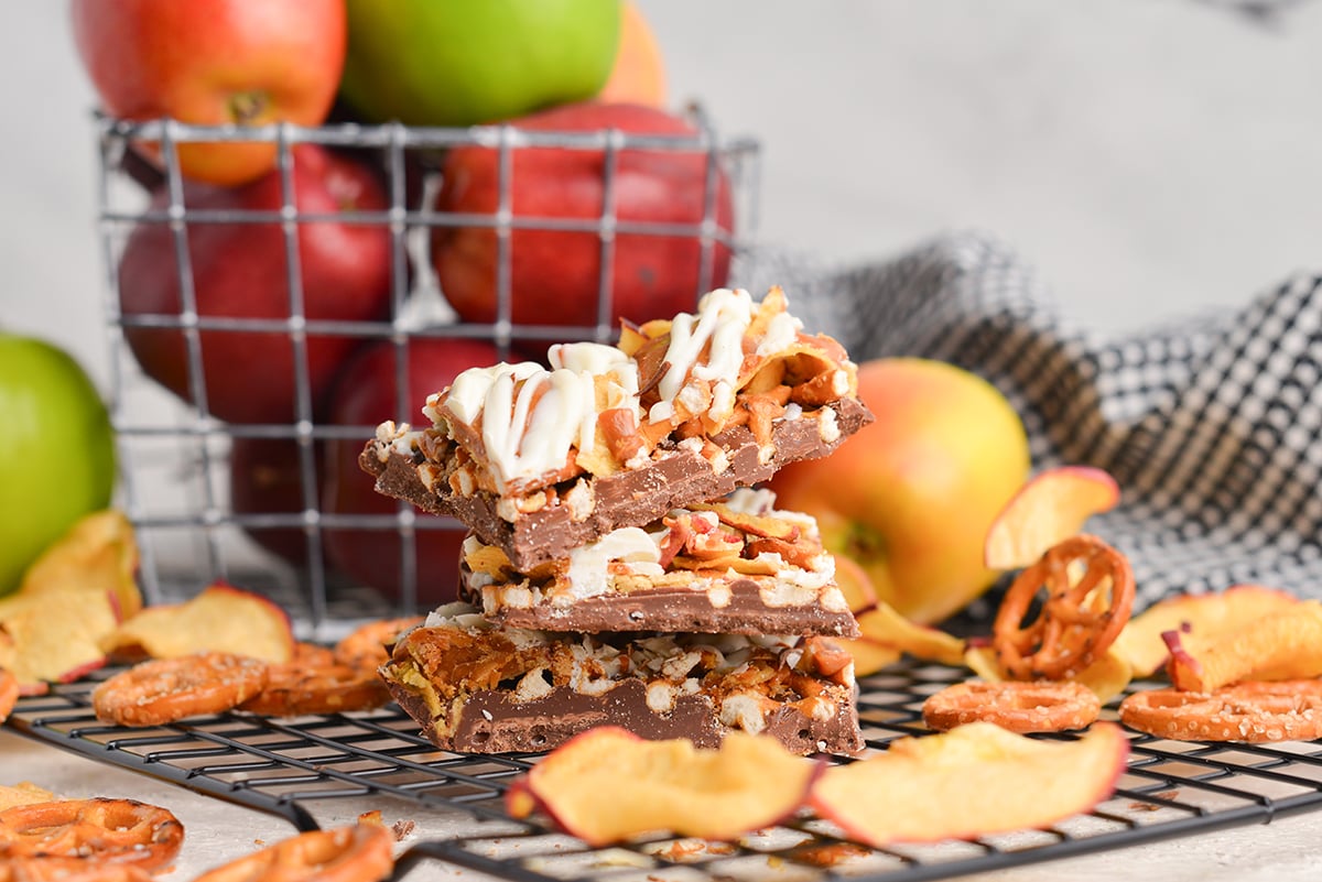 side view of stack of 3 pieces of bark with pretzels, apples, caramel and apples