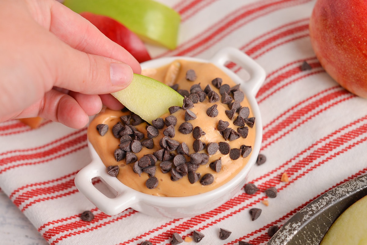 green apple dipping into caramel sauce