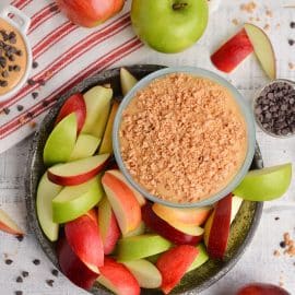 caramel dessert dip topped with toffee bits surrounded by apple slices