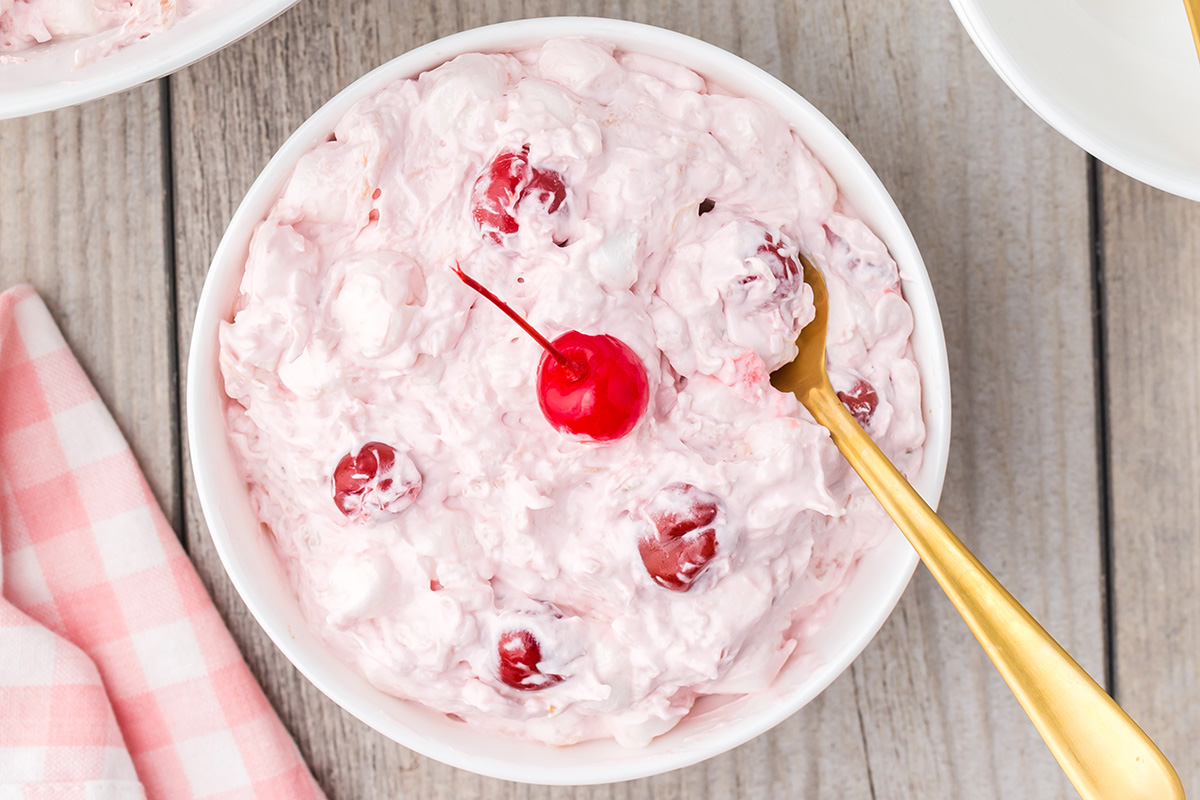 overhead shot of bowl of classic cherry fluff with spoon in it