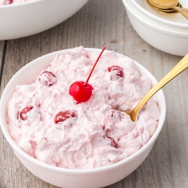 angled shot of bowl of cherry fluff with spoon in it