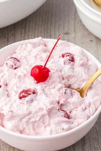 angled shot of bowl of cherry fluff with spoon in it