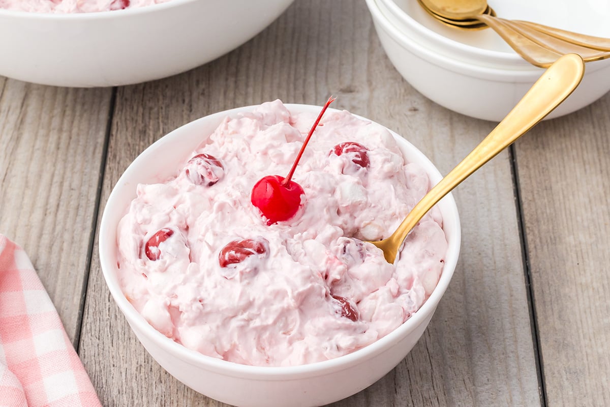 angled shot of bowl of cherry fluff with spoon in it