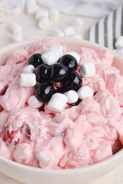 angled shot of cherry fluff topped with marshmallows and cherries