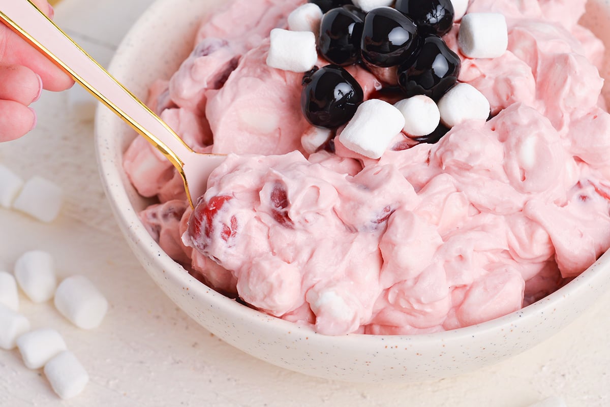 angled shot of spoon in bowl of cherry fluff