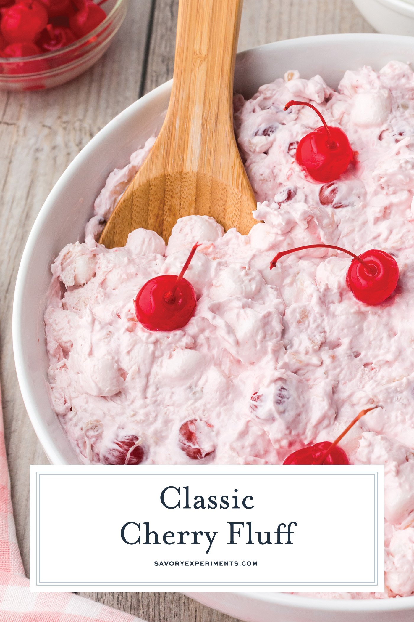 angled shot of wooden spoon in bowl of classic cherry fluff with text overlay for pinterest