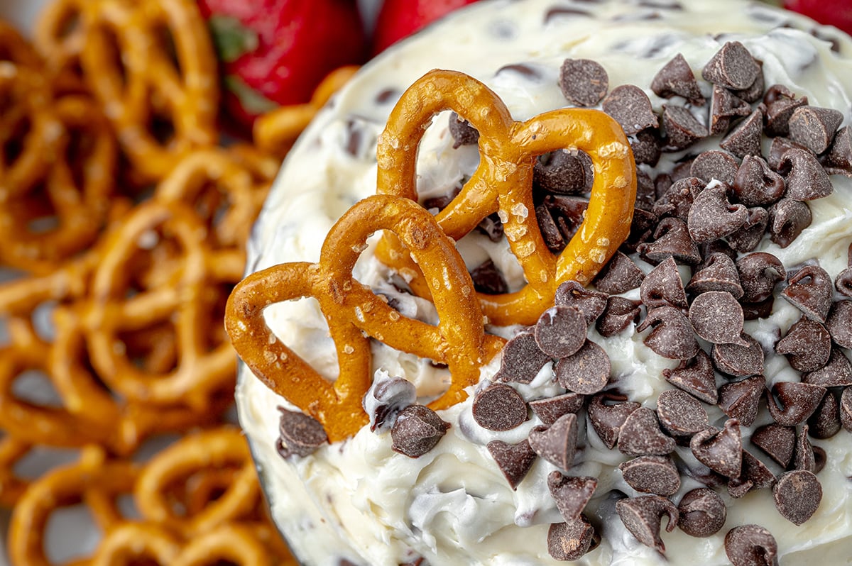 pretzels dipping into cookie dough dip