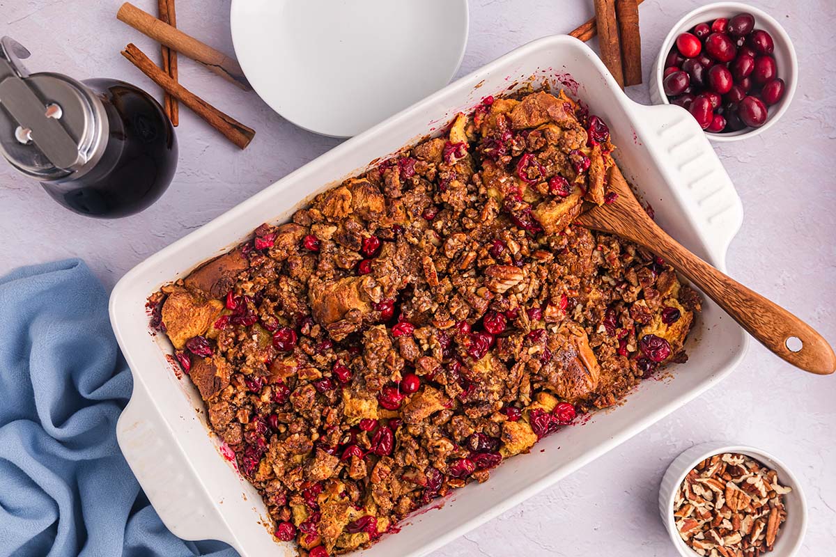 overhead shot of wooden spoon in baking dish of cranberry french toast casserole