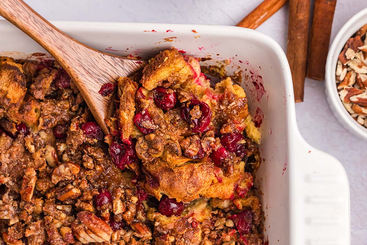 close up angled shot of wooden spoon scooping out cranberry french toast casserole