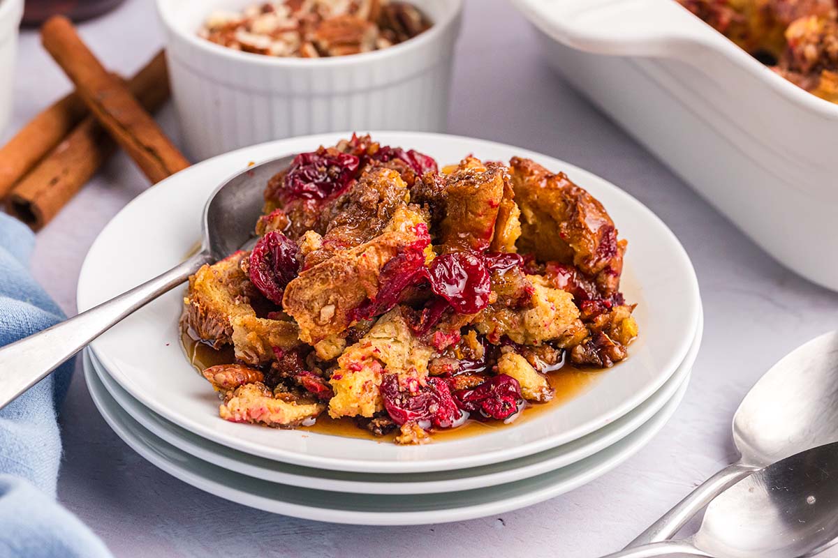 close up angled shot of cranberry french toast casserole on plate with spoon