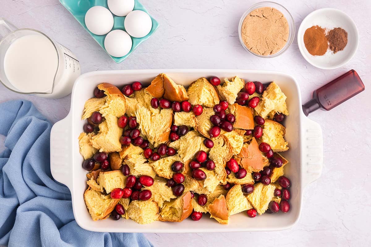 overhead shot of bread pieces in baking dish with cranberries