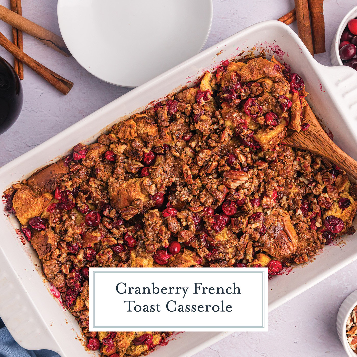 overhead shot of wooden spoon in cranberry french toast casserole dish with text overlay for facebook