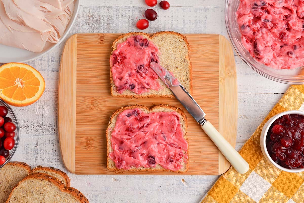 spreading cranberry mayo on to whole wheat bread