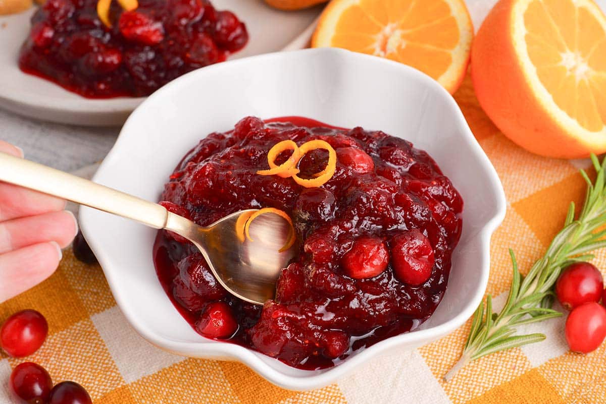 gold spoon serving orange cranberry sauce