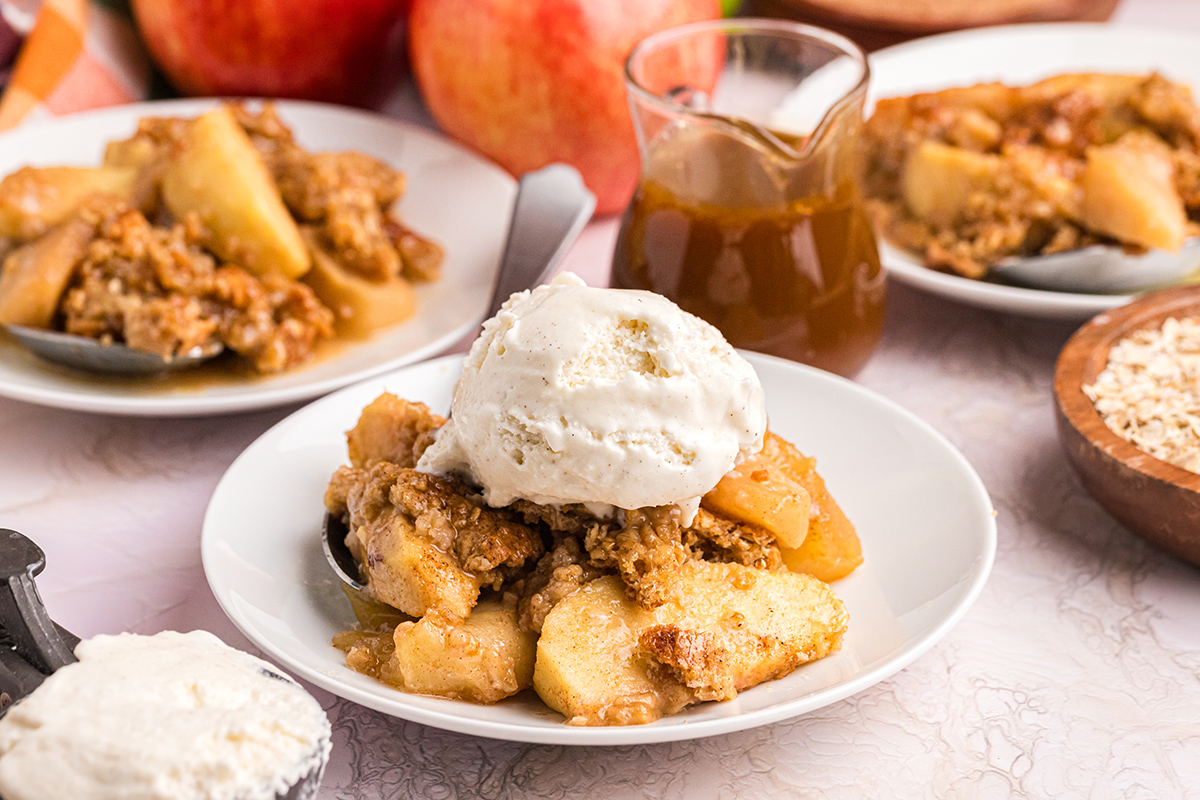 straight on shot of ice cream on top of plate of apple crisp