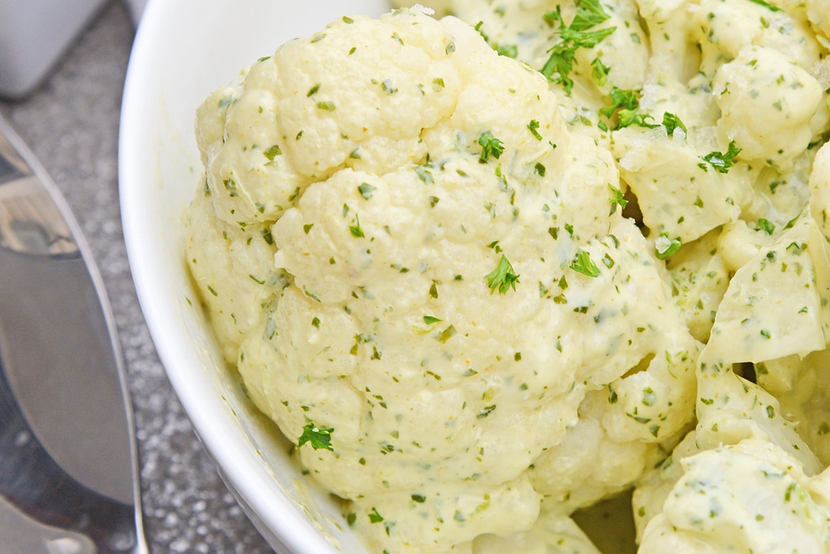 close up of roast cauliflower with sauce and parsley