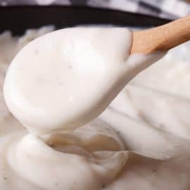 close up of a spoon with white gravy using roux