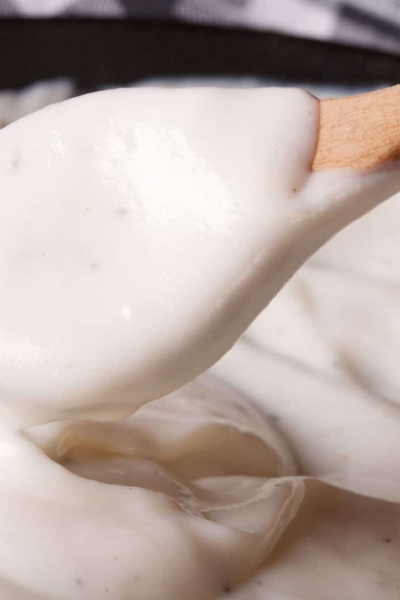 close up of a spoon with white gravy using roux