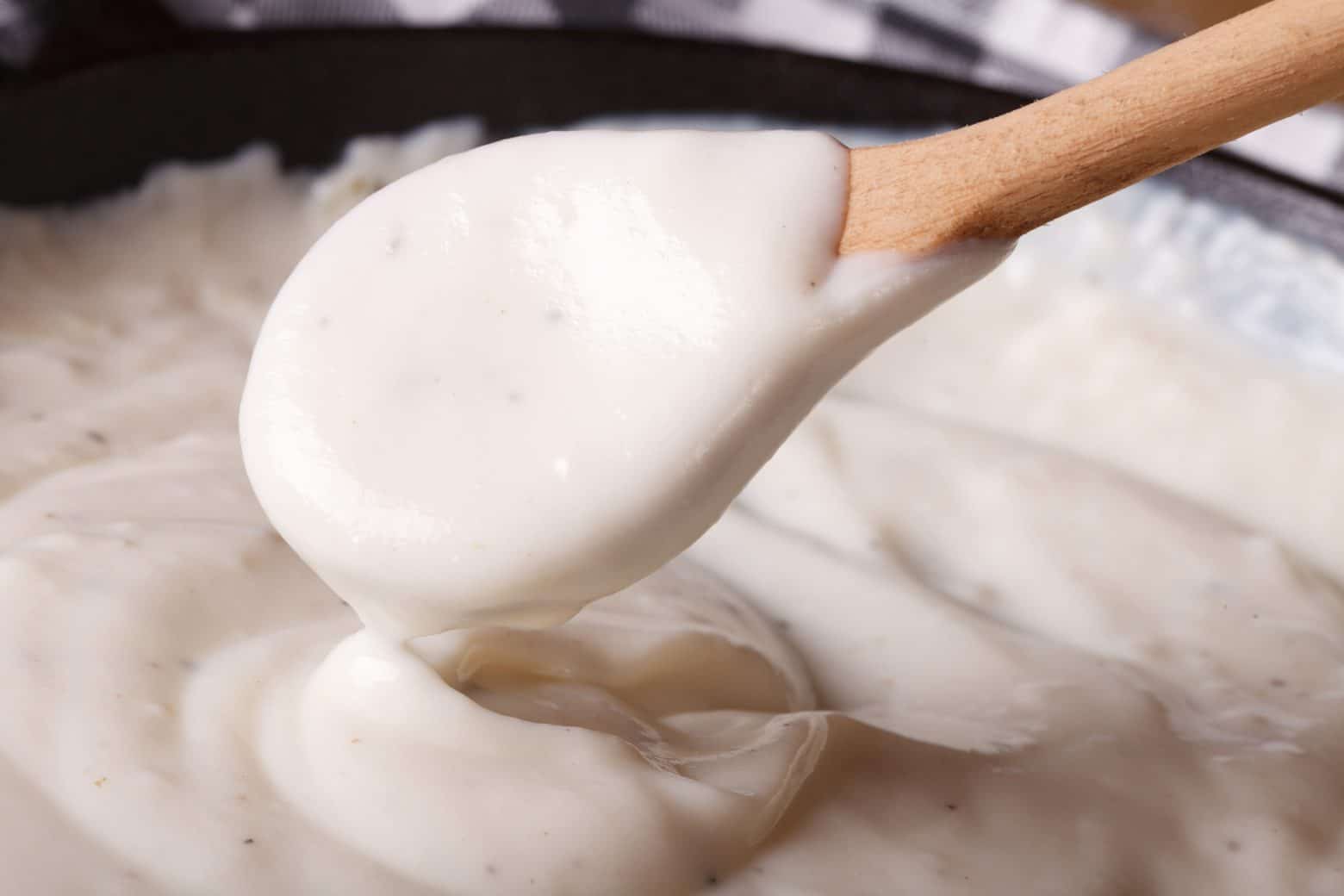close up of a spoon with white gravy using roux