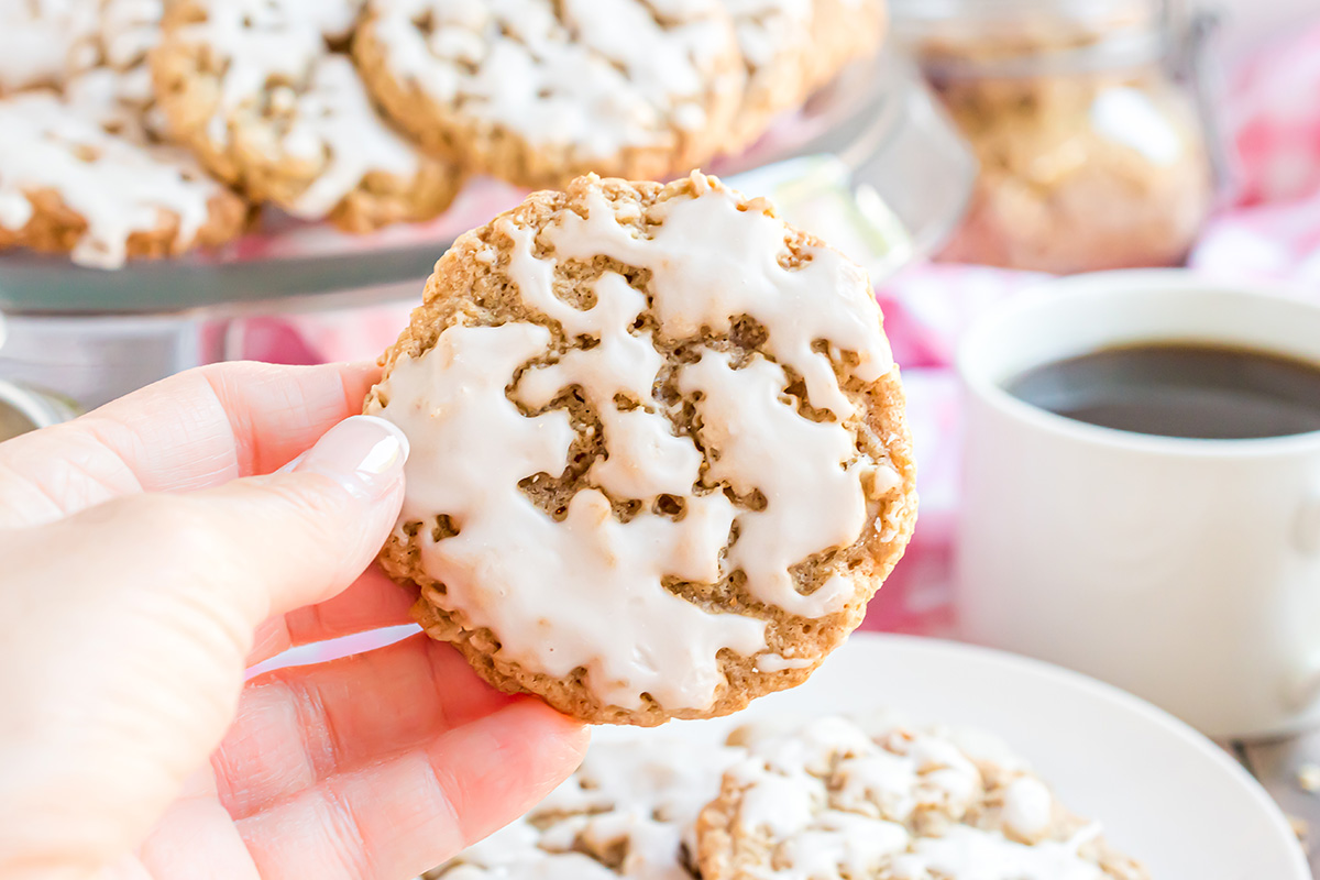 Hand holding an iced oatmeal cookie