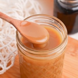 angled shot of spoon in jar of sauce