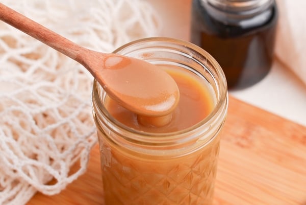 angled shot of spoon in jar of sauce