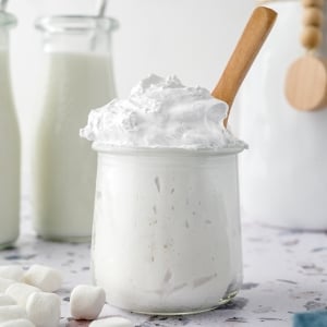 glass jar of fluff with a wooden spoon