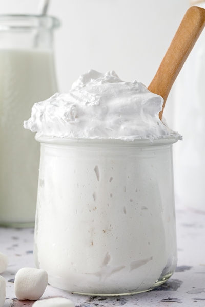 glass jar of fluff with a wooden spoon