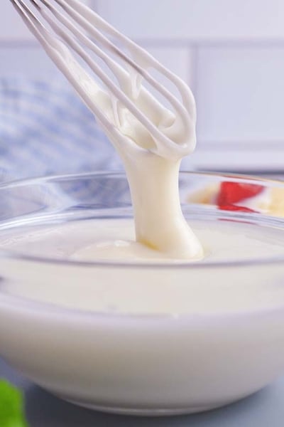 whisk drizzling mixed icing into a bowl