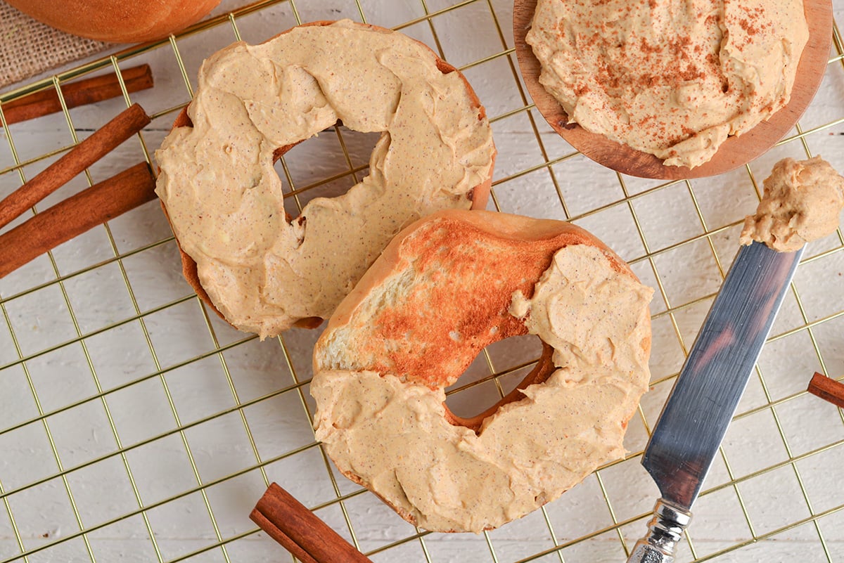 overhead shot of pumpkin cream cheese spread onto bagels