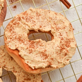 close up angled shot of pumpkin cream cheese on bagel