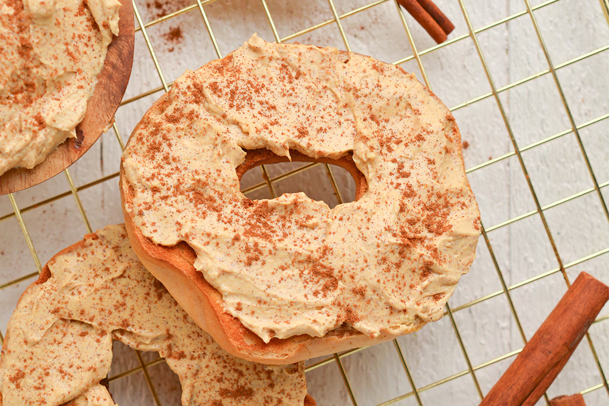 close up angled shot of pumpkin cream cheese on bagel
