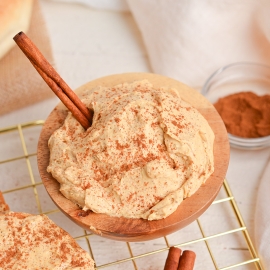 angled shot of pumpkin cream cheese in bowl with cinnamon stick