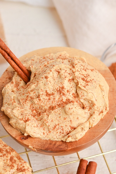 angled shot of pumpkin cream cheese in bowl with cinnamon stick