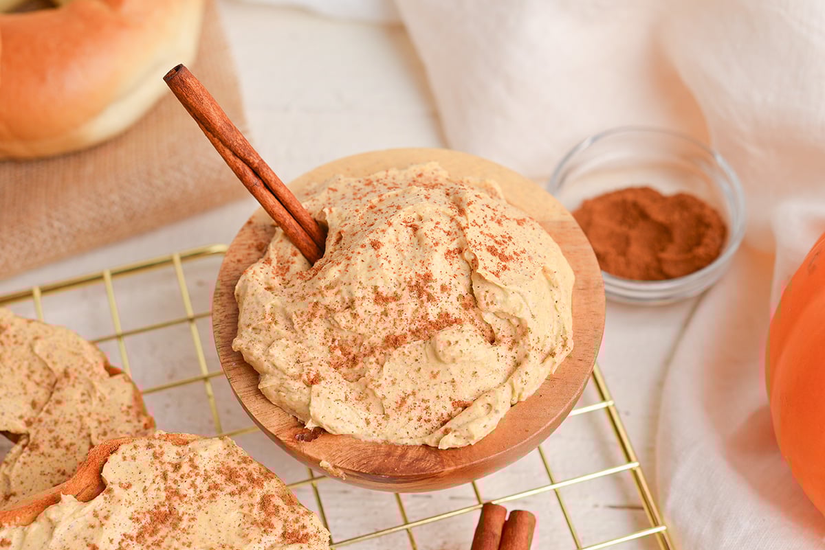 angled shot of pumpkin cream cheese in bowl with cinnamon stick