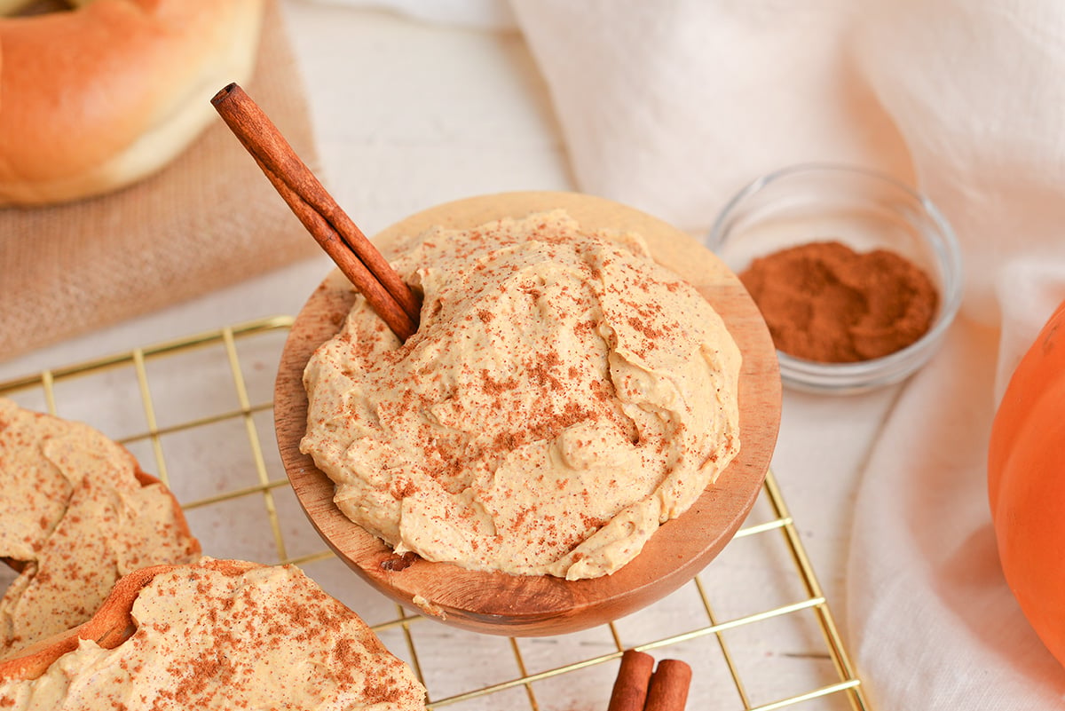 angled shot of pumpkin cream cheese in bowl with cinnamon stick